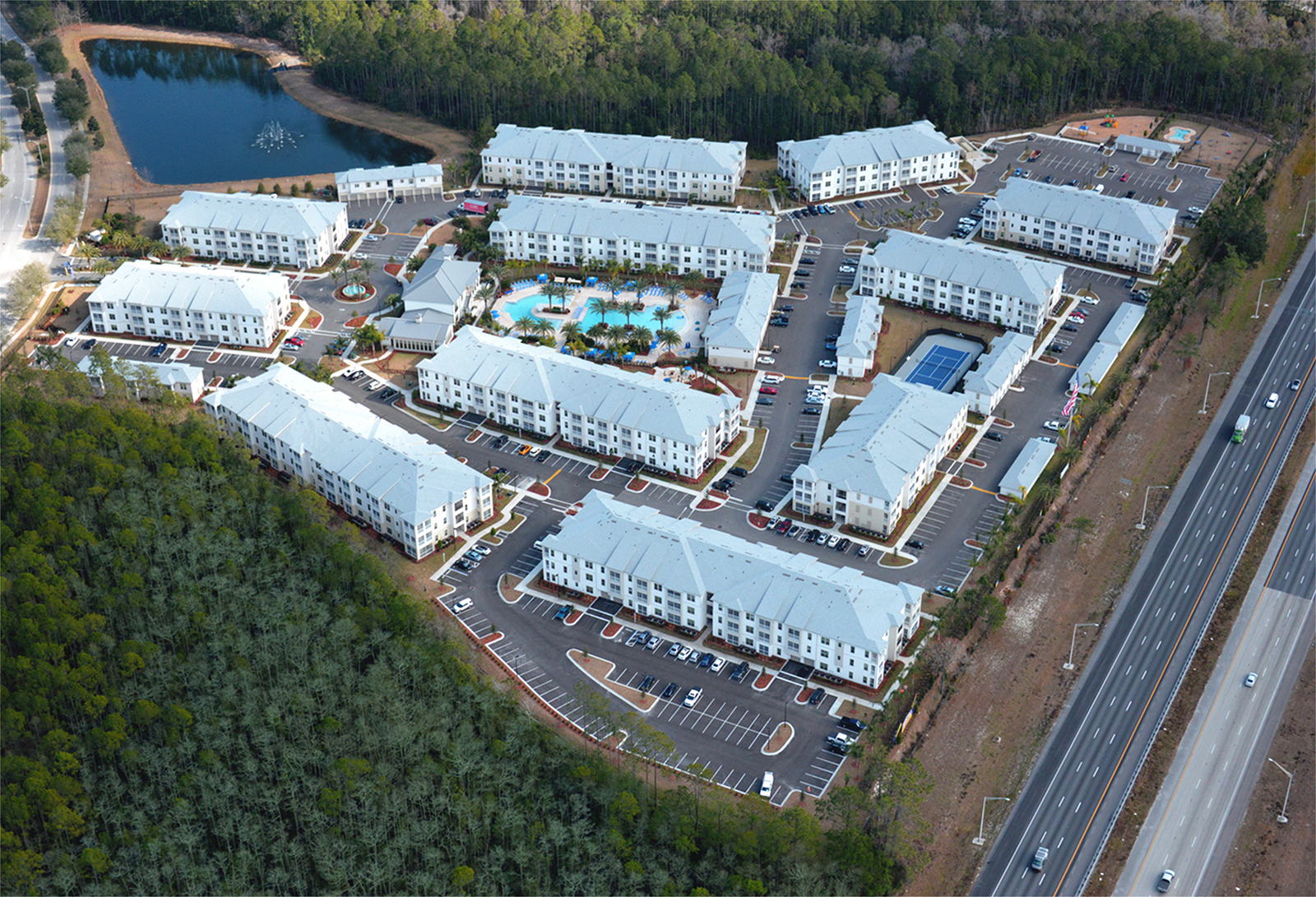 Aerial shot of apartment complex with pool area and palm trees
