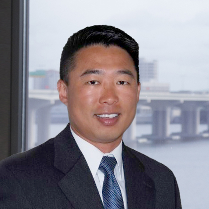 Asian man in suit smiling at camera