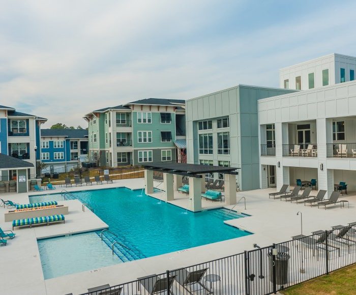 Light blue apartment building with pool area