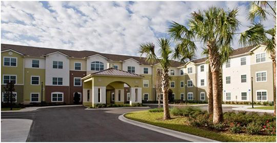 Senior living entrance with palm trees