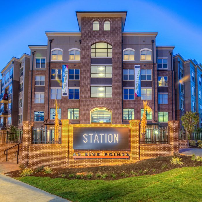 Multi level student housing at night with Station at Five Points sign