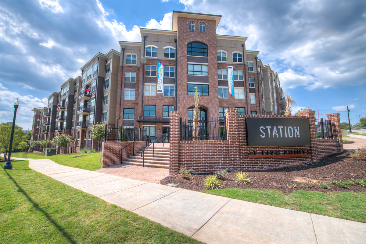 Brick Multi level student housing with Station at Five Points sign