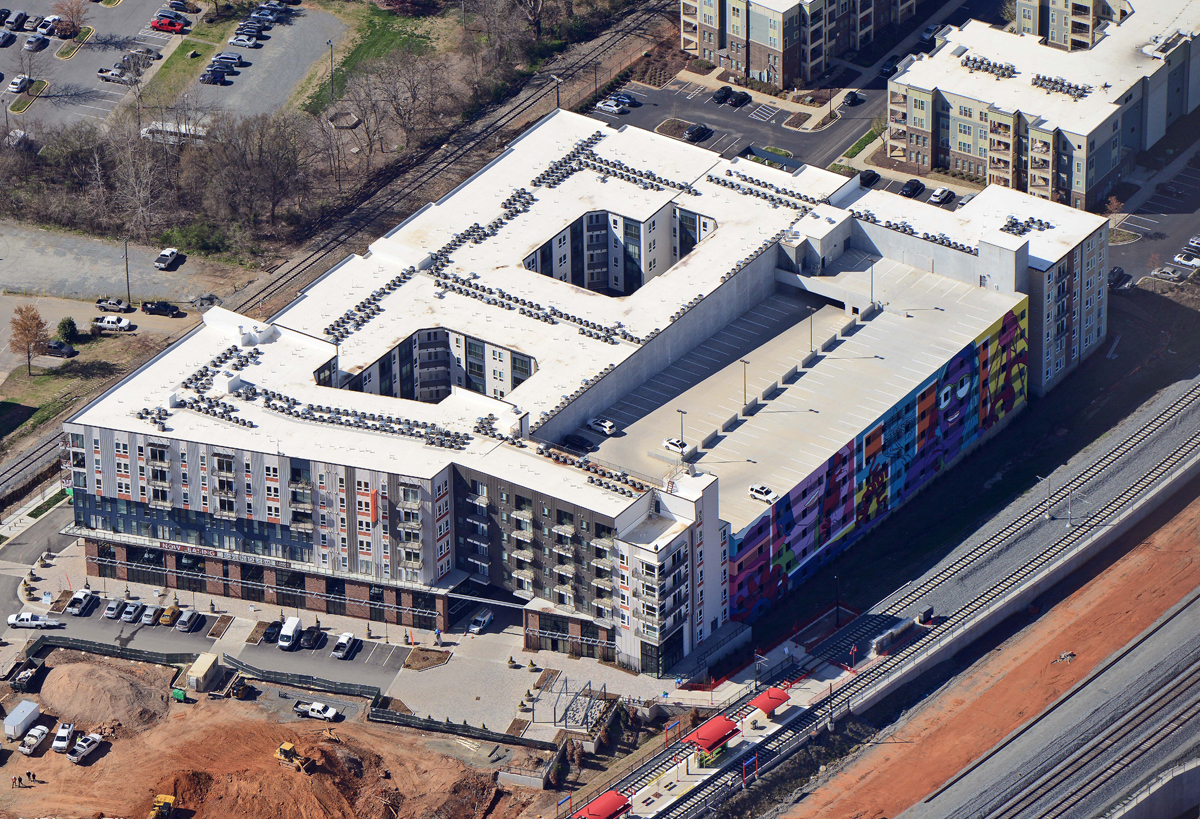 Luxury apartment complex next to light rail system aerial view