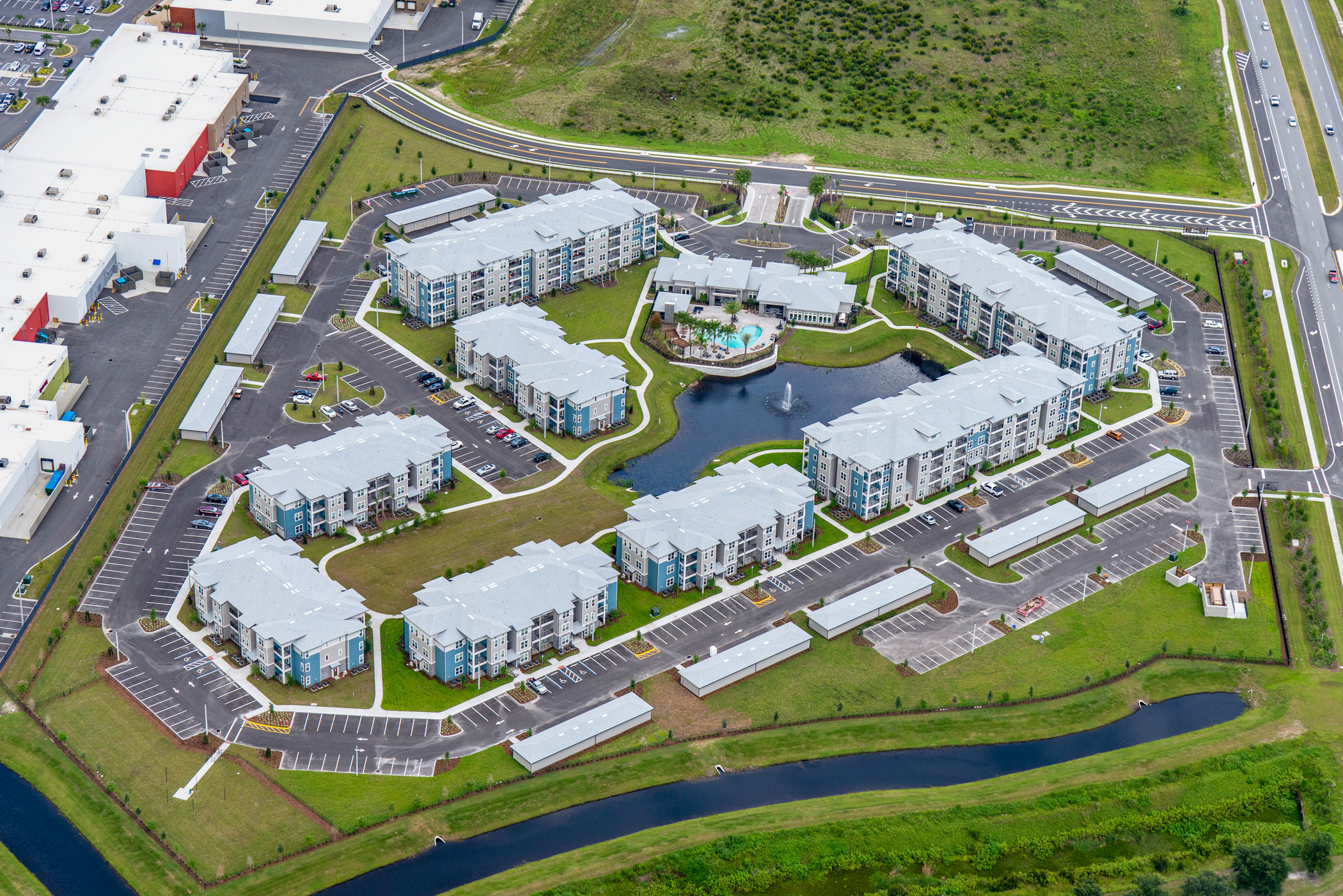 Multi story apartment building with pond aerial view