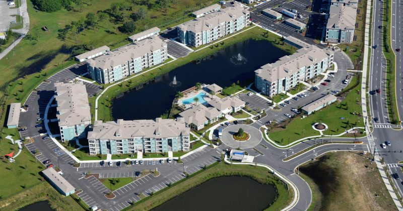 Multi story apartment complex with pond and fountains aerial shot