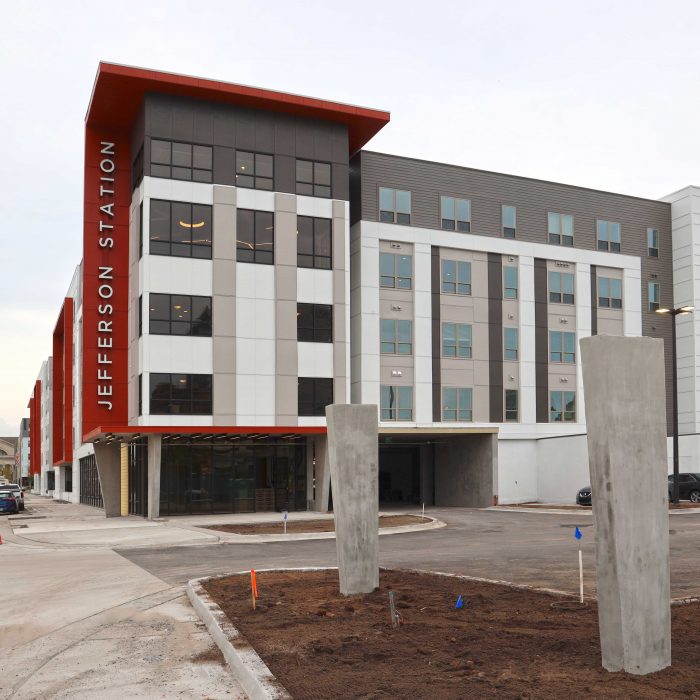 Red white and gray multi story apartment building with Jefferson Station sign