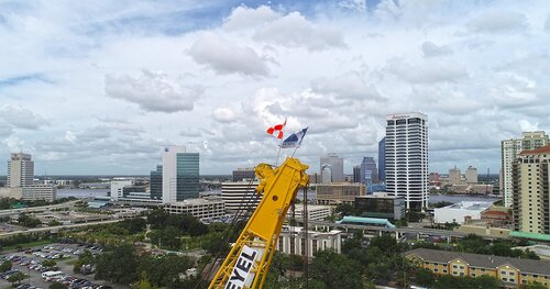 Crane with flags in front of Jacksonville's downtown