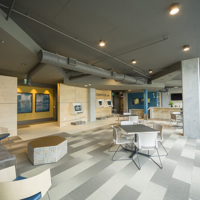 Modern lounging area with patterned floor, chairs, and computer lab sign