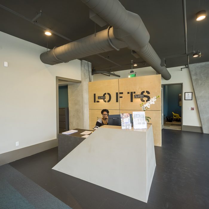Smiling receptionist with Lofts sign behind her