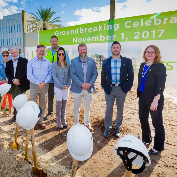 Executives and contractors smiling with shovels at new site