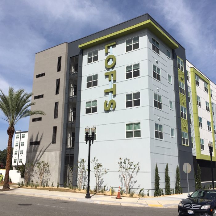 Multi story apartment complex entrance with 'Lofts' lettering on side