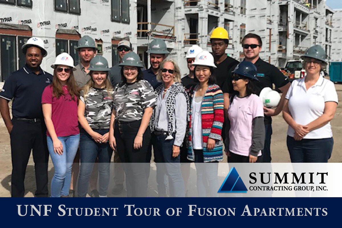 Students and Summit employees in hard hats at construction site