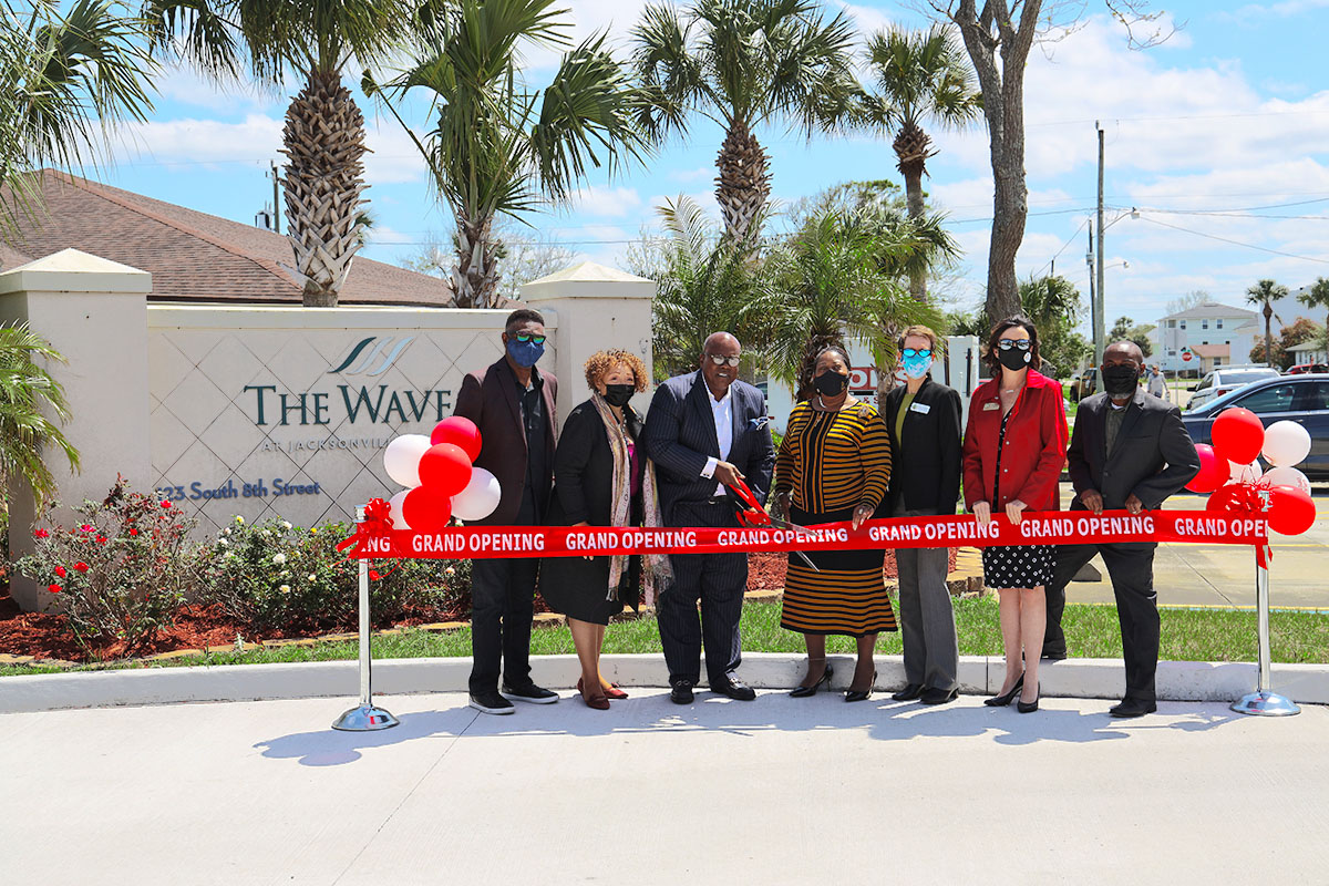 group of people cutting a ribbon at opening ceremony