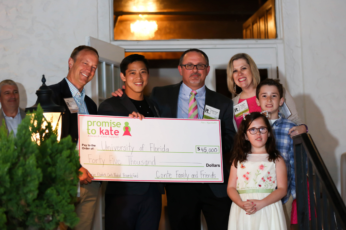 Group photo holding a large donation check for Promise to Kate to UF