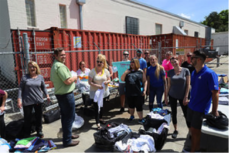 Photo of volunteers sorting shirts at Uplifting Volunteer Day by Summit Contracting Group