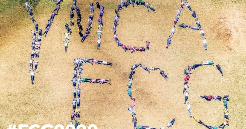 Aerial view of "YMCA FCG" spelled by people doing yoga for #FCG2020