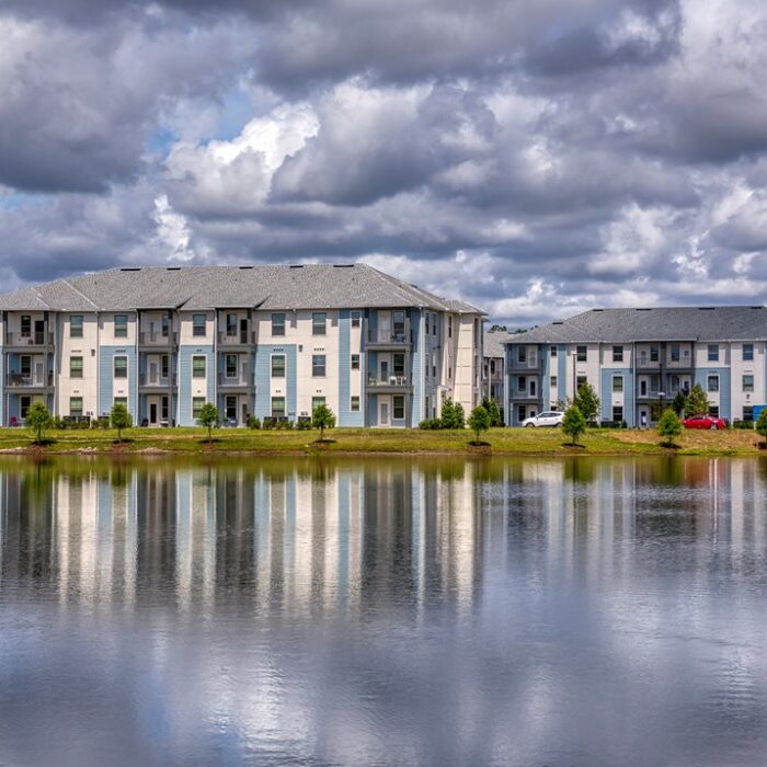 3 story apartment building across a lake