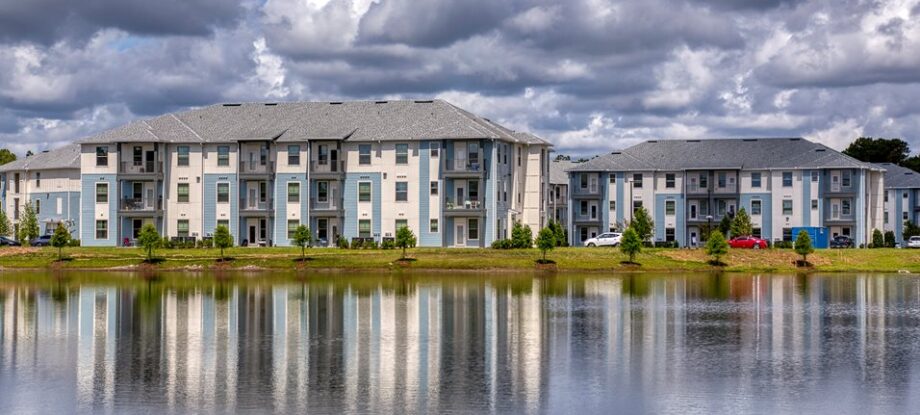 3 story apartment building across a lake