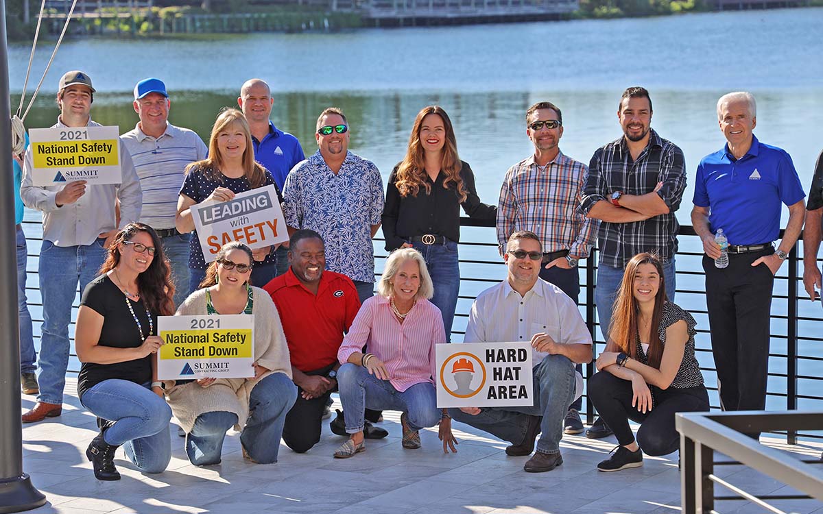 group of people posing on a deck holding signs