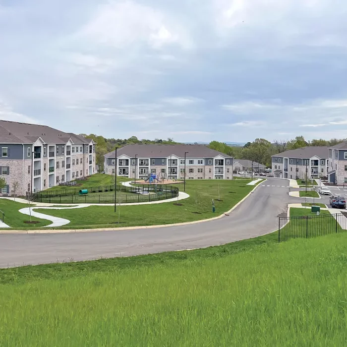 grassy hill overlooking a group of apartment buildings