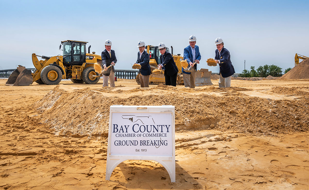 line of people shoveling dirt at groundbreaking