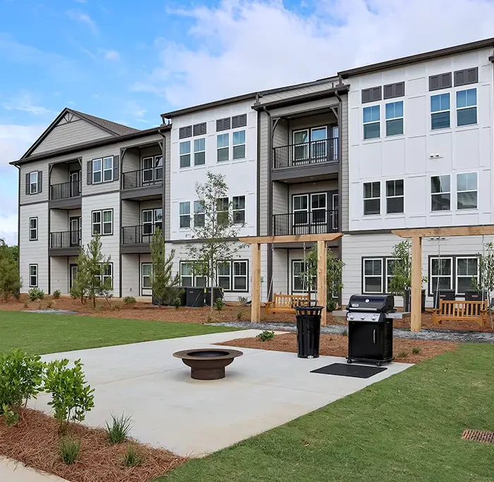 3 story apartment building with outdoor grilling patio and swing chairs