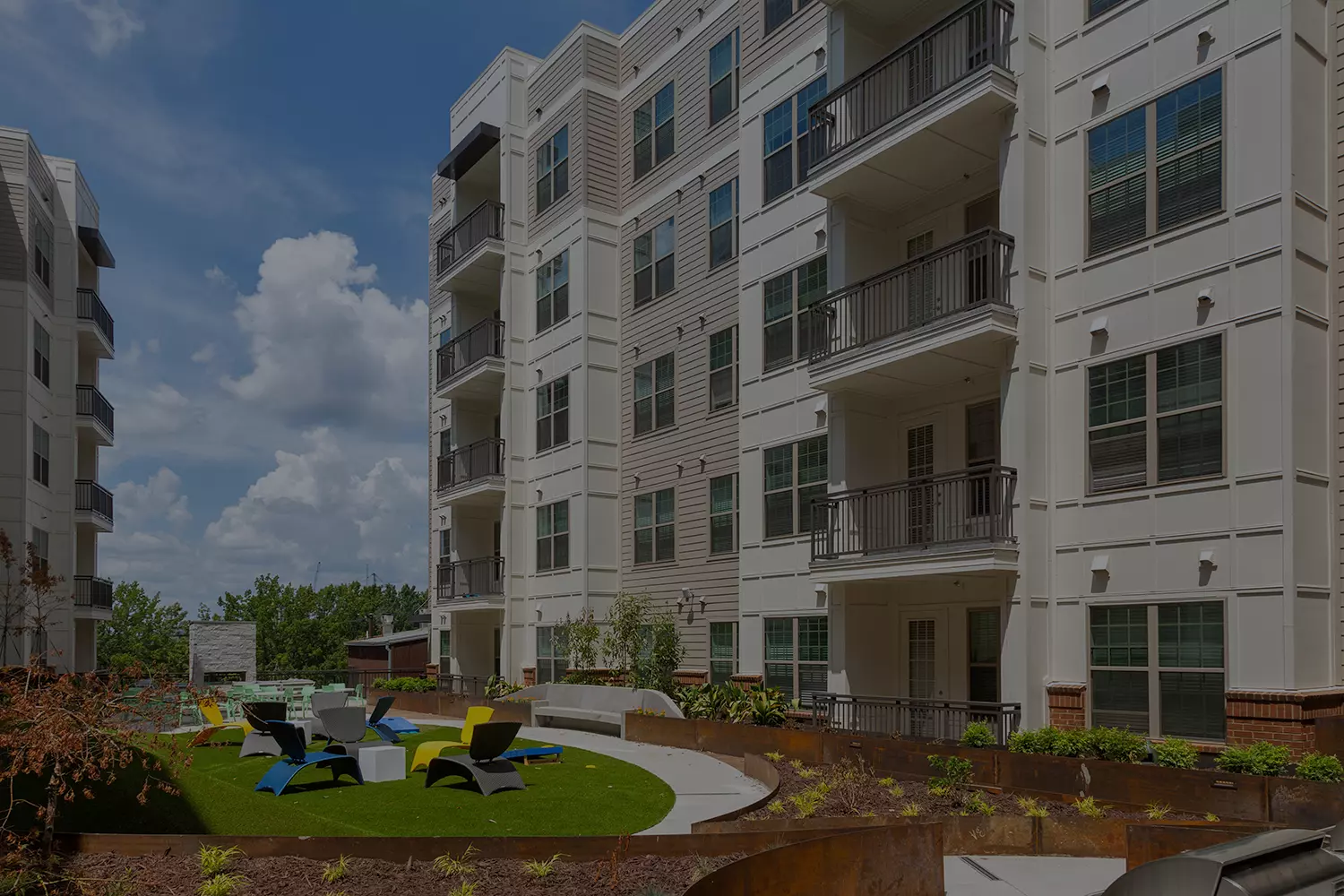 apartment courtyard with grills and lounge chairs
