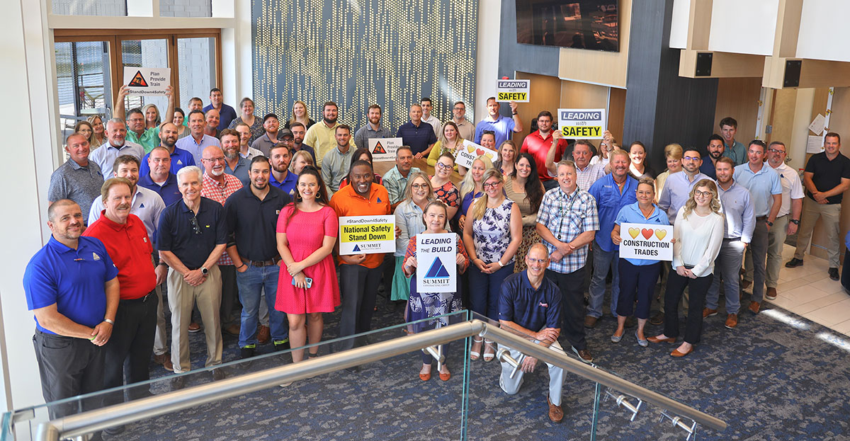 large group of employees standing together in an office lounge