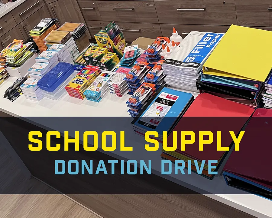 neatly stacked school supplies on a table being counted for donation