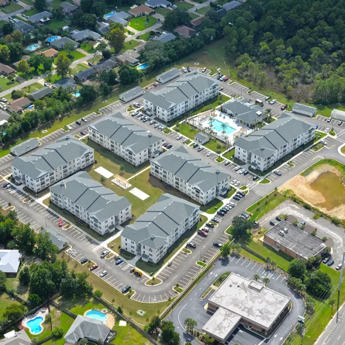 aerial view of apartment complex with 8 buildings and a swiming pool