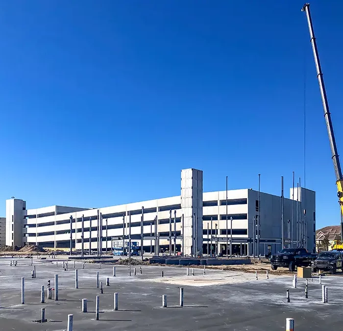 concrete parking garage under construction with crane