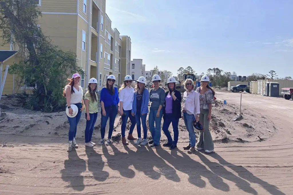 group with hard hats in front of building