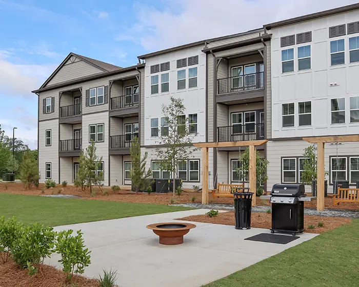 3 story apartment building with outdoor grilling patio and swing chairs