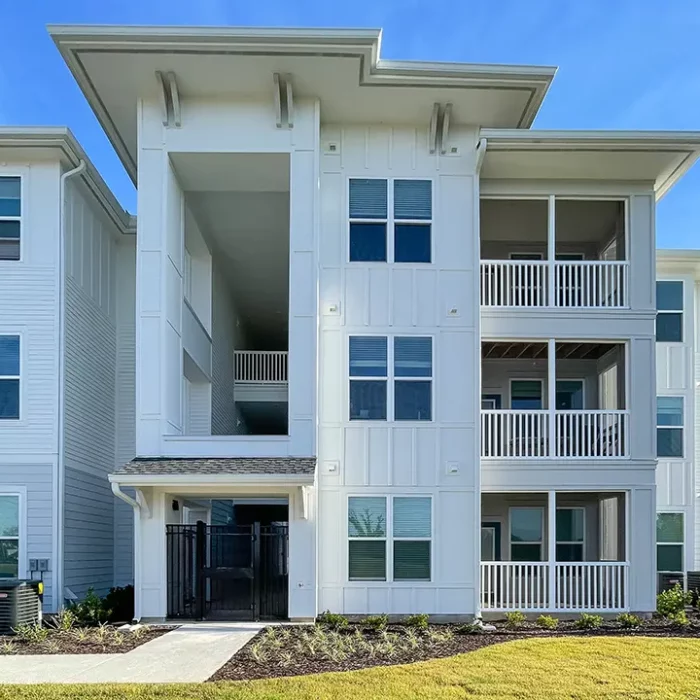 3 story building with screened balconies and an open breezeway