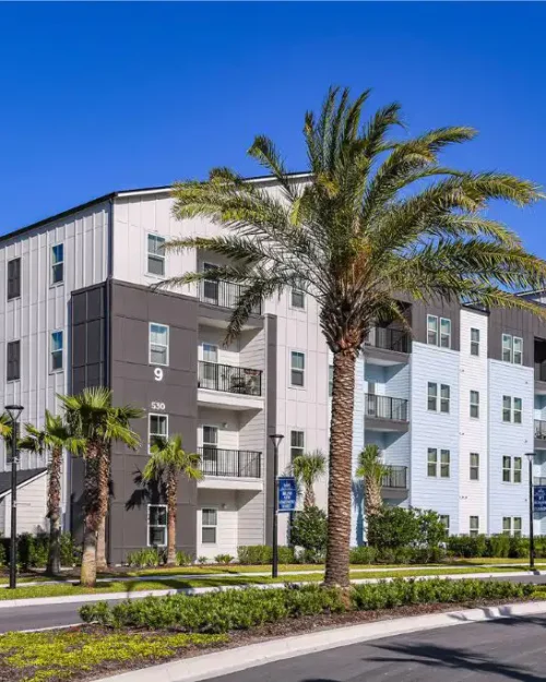 4 story apartment building with palm trees