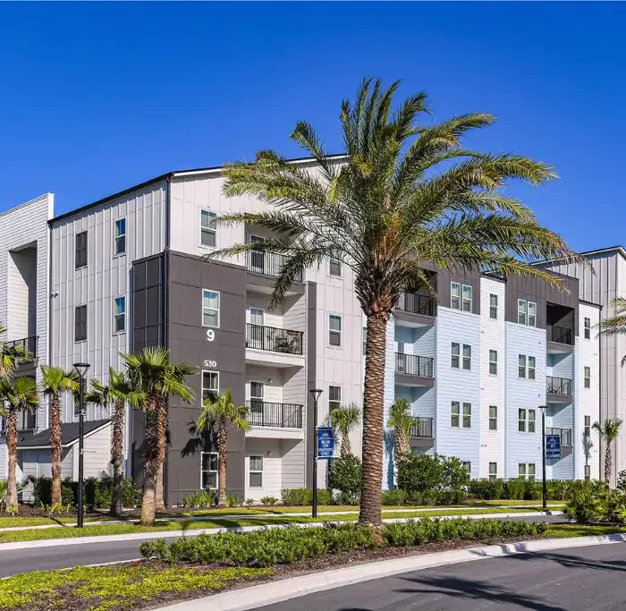 4 story apartment building with palm trees