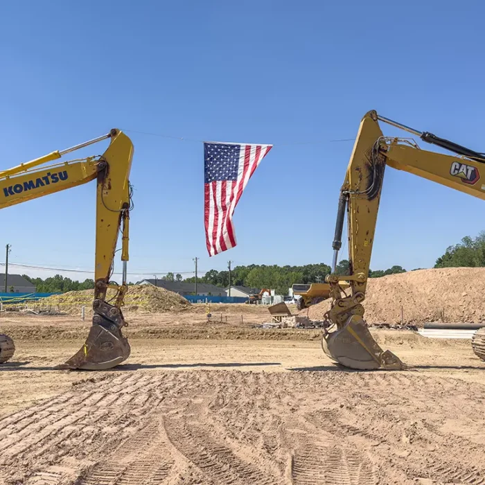 American Flag hung between 2 large excavators on a construction site