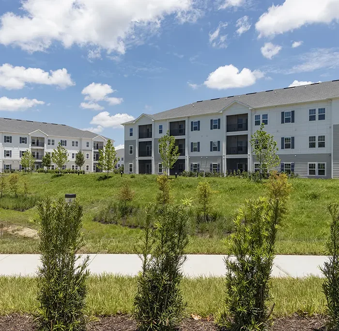 apartments buildings with a sidewalk and green shrub landscaping